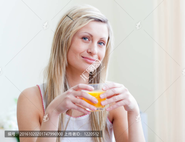 一個(gè)迷人的女人喝橙汁的肖像