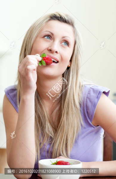 一個(gè)美麗的女人吃草莓的肖像