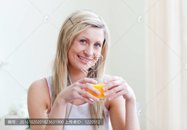 一個(gè)快樂(lè)的女人喝橙汁的肖像