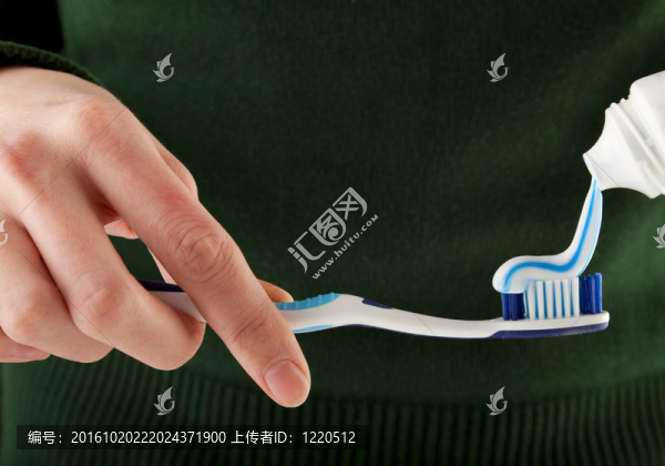 女性手把牙膏放在牙刷上