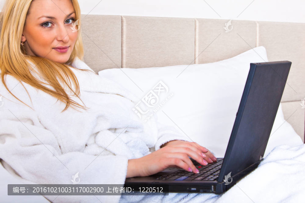 女人坐在床上使用筆記本電腦