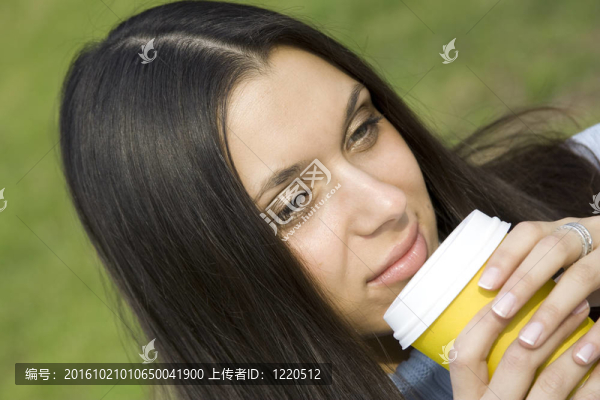 美麗的女孩在公園喝咖啡