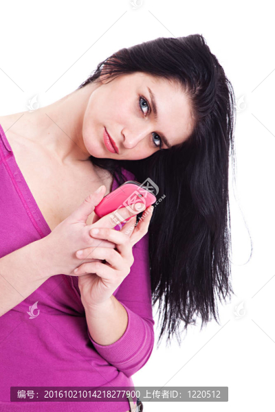 美麗的年輕女子在電話；看相機(jī)