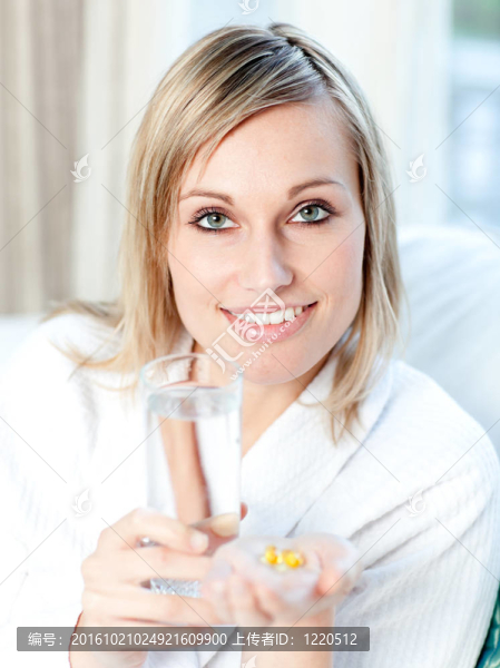 生病的白人婦女拿著一杯水和藥丸
