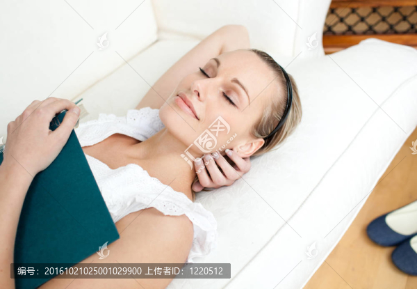 疲倦的女人一邊看書一邊睡覺
