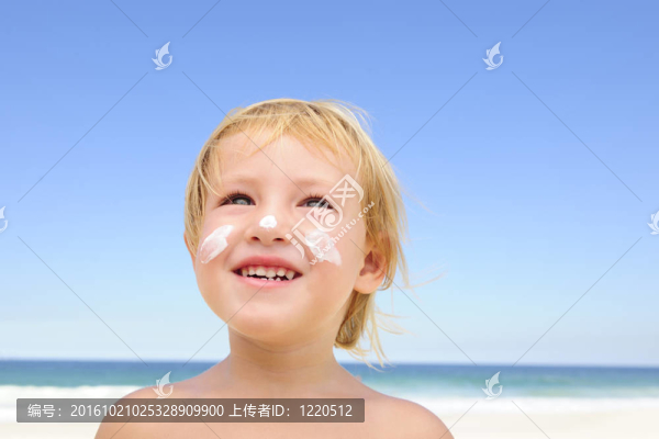 可愛(ài)的孩子在海灘上涂防曬霜
