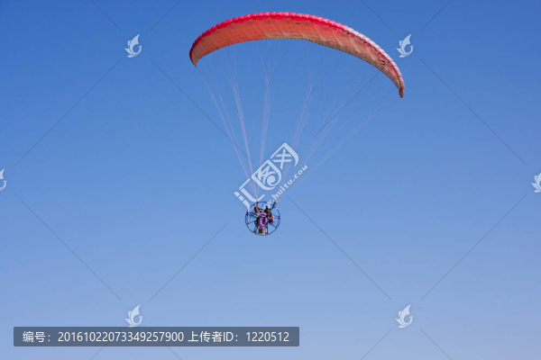 動(dòng)力滑翔傘飛行員在背景中的藍(lán)天飛行