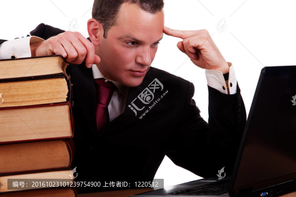 商人在書桌上看書；看電腦；在白色背景下孤立；攝影棚。