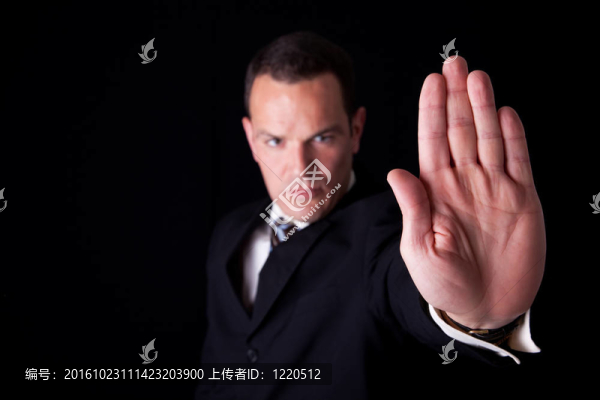 商人用手舉起信號停止；在黑色背景上孤立；工作室拍攝