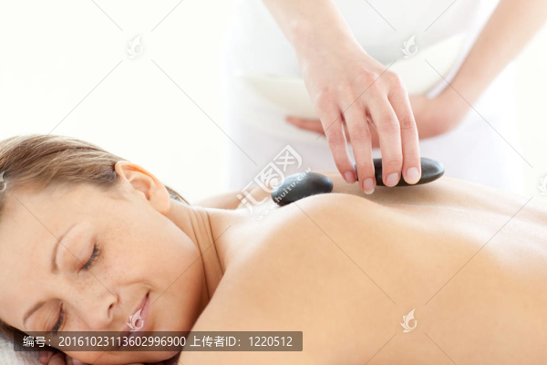 一個(gè)容光煥發(fā)的女人用石頭按摩的肖像