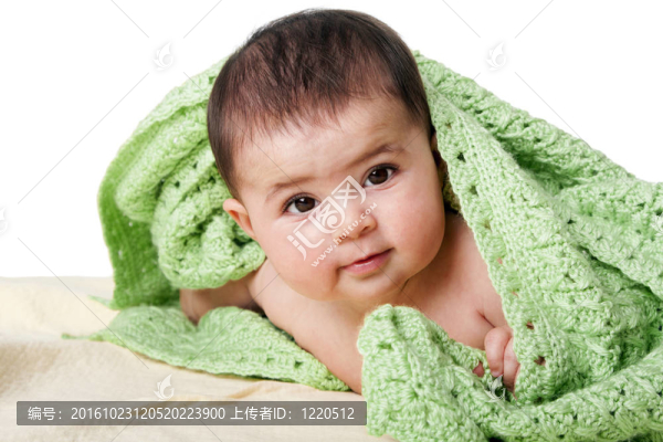 可愛的幸福嬰兒之間的綠色毛毯