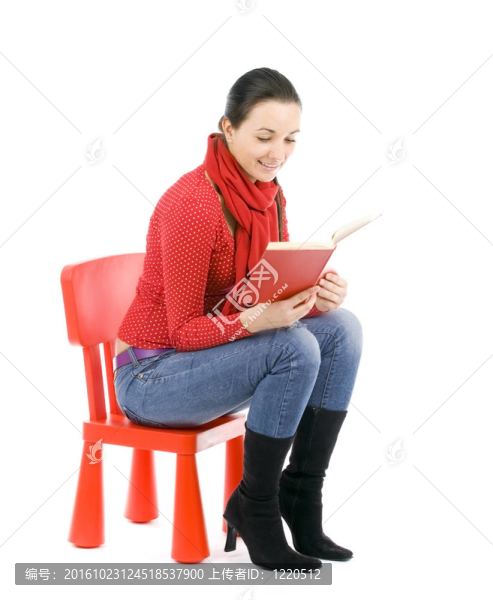坐在紅色的；孩子的椅子年輕女子讀書