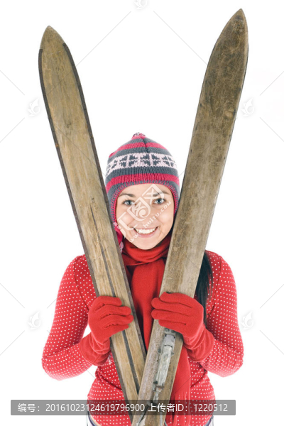 微笑的年輕女子在冬季帽持有舊木滑雪