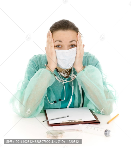 用帶著手銬的雙手在辦公室綠色制服和醫(yī)用口罩嚇壞了的女醫(yī)生