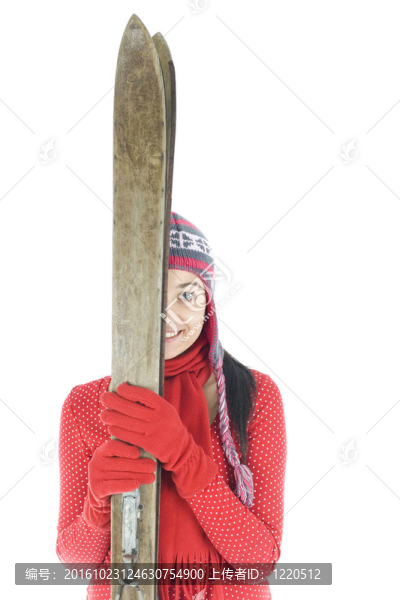 微笑的年輕女子在冬季帽持有舊木滑雪
