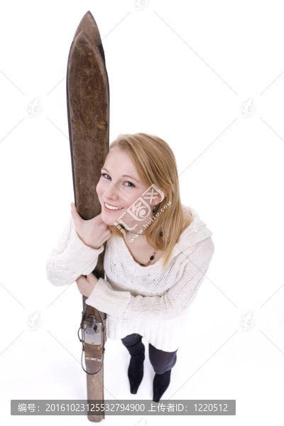 年輕女子抱著舊木滑雪的肖像
