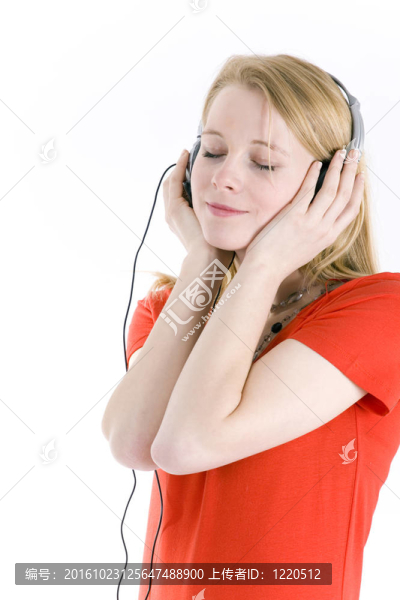 從MP3播放器的耳機(jī)聽音樂的年輕女孩。白色的背景。