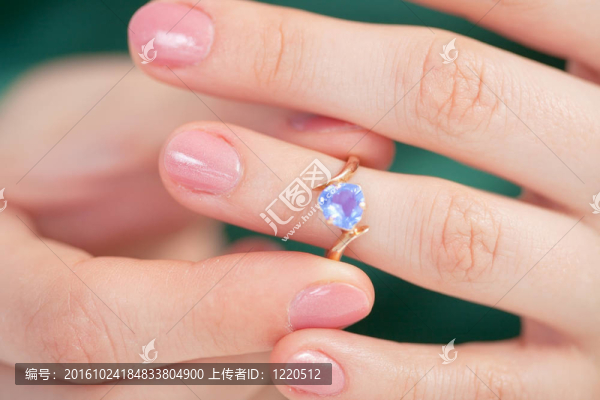 金色戒指戴著藍(lán)色的寶石試著用手指