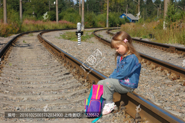 在鐵路鐵軌上帶著背包的小女孩