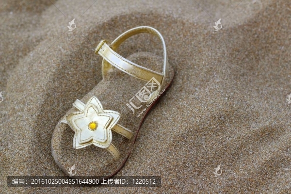 金色的星星涼鞋埋在夏天的沙灘