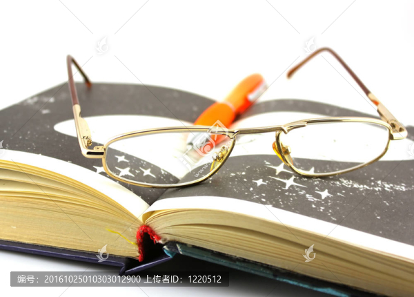 舊書；眼鏡和筆。淺景深。