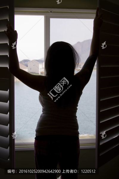 一個女人的剪影靠窗伸展