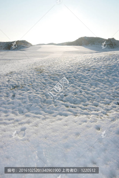 白色冰雪覆蓋的高爾夫球場上的腳印