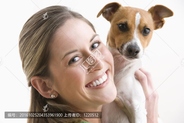 迷人的年輕女子抱著狗微笑