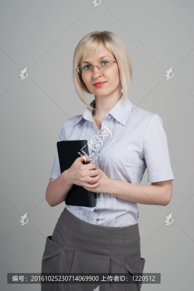 年輕漂亮的女商人拿著日記孤立的灰色