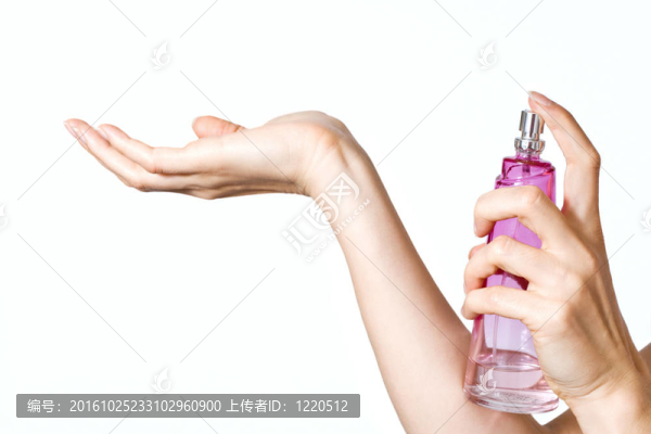 女人的手與粉紅色的香水瓶