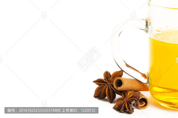 半杯黃茶；兩肉桂和八角白色背景