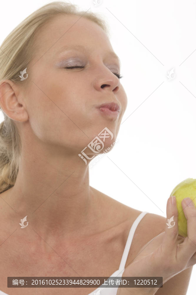 年輕美麗的白人女性的飲食和在手里拿著蘋果
