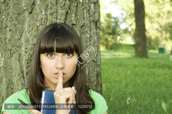 女的在一個(gè)公園里帶著一本筆記本
