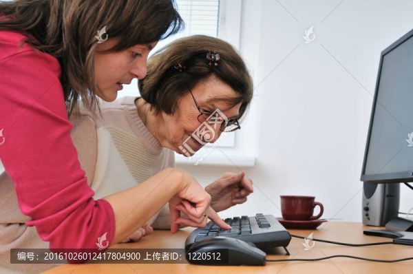 年輕婦女教奶奶用電腦工作