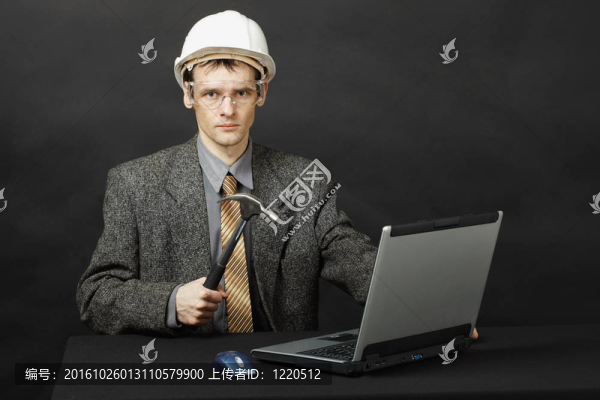 戴頭盔的男子用錘子修理電腦