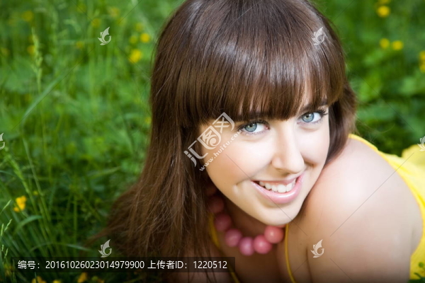 年輕漂亮的女人躺在綠草上