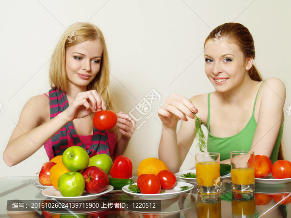 两个女孩在桌子后面有蔬菜和水果