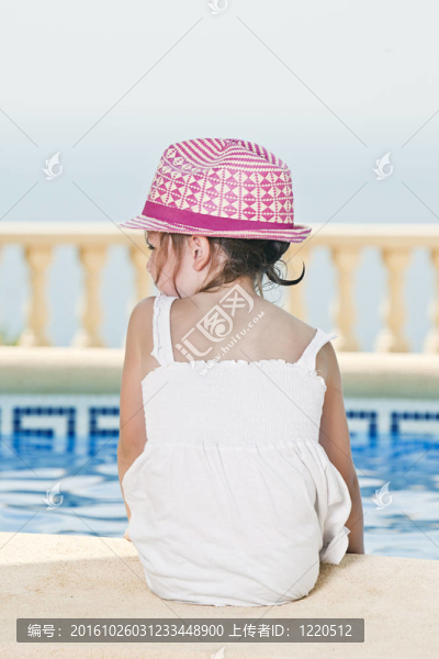 可愛的小孩子坐在池邊
