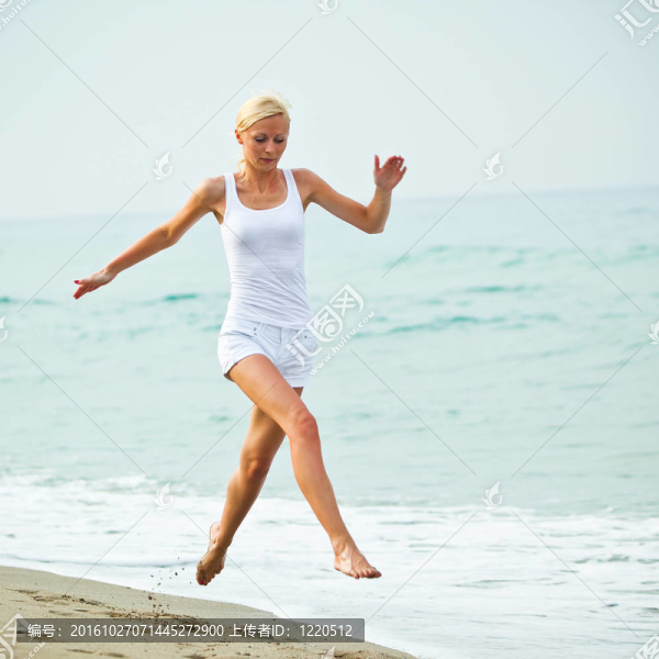 快樂的年輕女子在海灘上跳