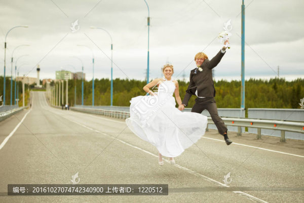 新婚夫婦在公路上跳