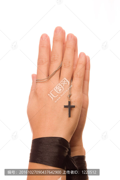 女人祈禱著握著她的十字架。