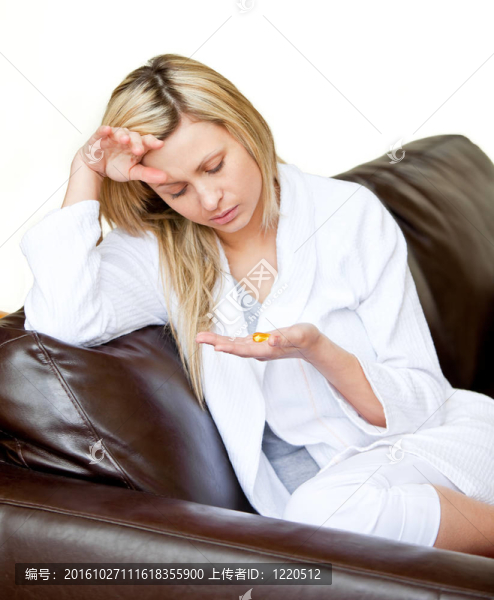 生病的年輕女人拿著藥