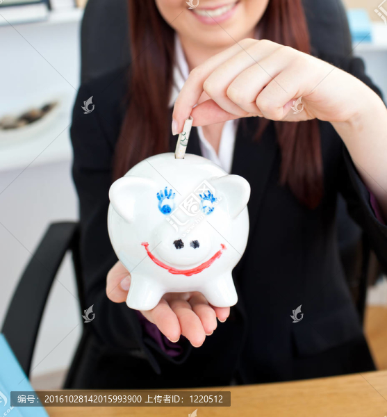 靠近一個(gè)年輕的商人拿著一piggibank