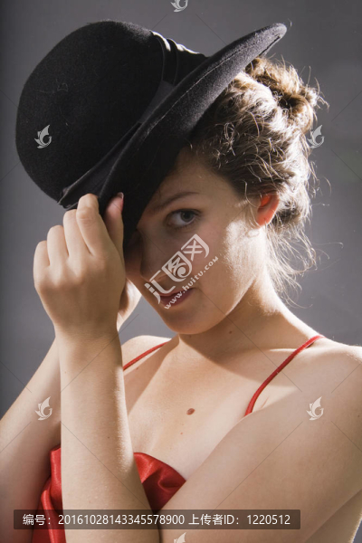 女人看相機(jī)。優(yōu)雅的年輕女人在一頂黑色的帽子。