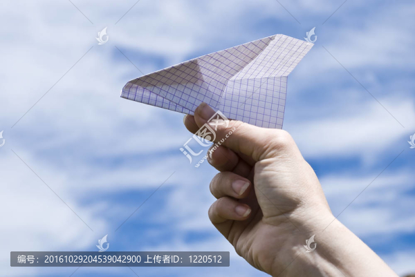 手拿紙飛機在天空背景