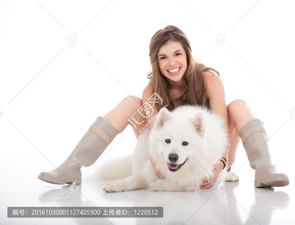 年輕女子抱著她的白色狗在她面前