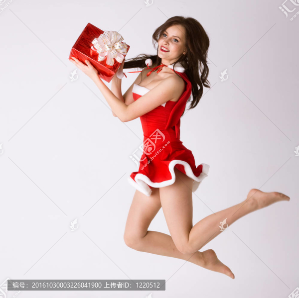 微笑的紅色圣誕禮物的女人性感的服裝飛