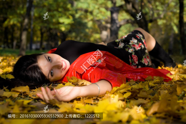 年輕女子在秋天公園在地上