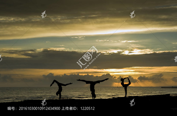 日落時(shí)在海灘上做伸展運(yùn)動(dòng)的三位年輕女子的剪影