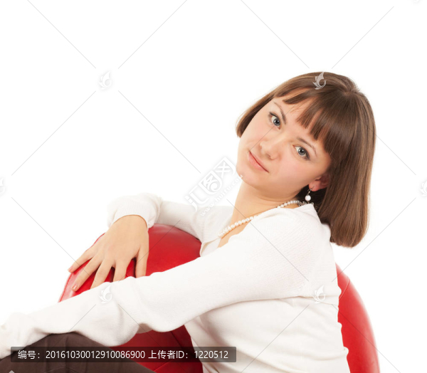 漂亮的金發(fā)女孩在紅色的真皮椅子